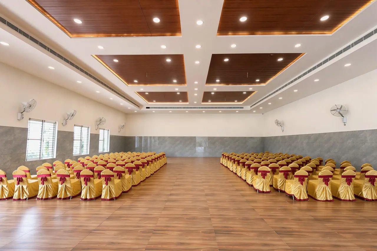 The grand banquet hall set with covered chairs for a wedding reception
