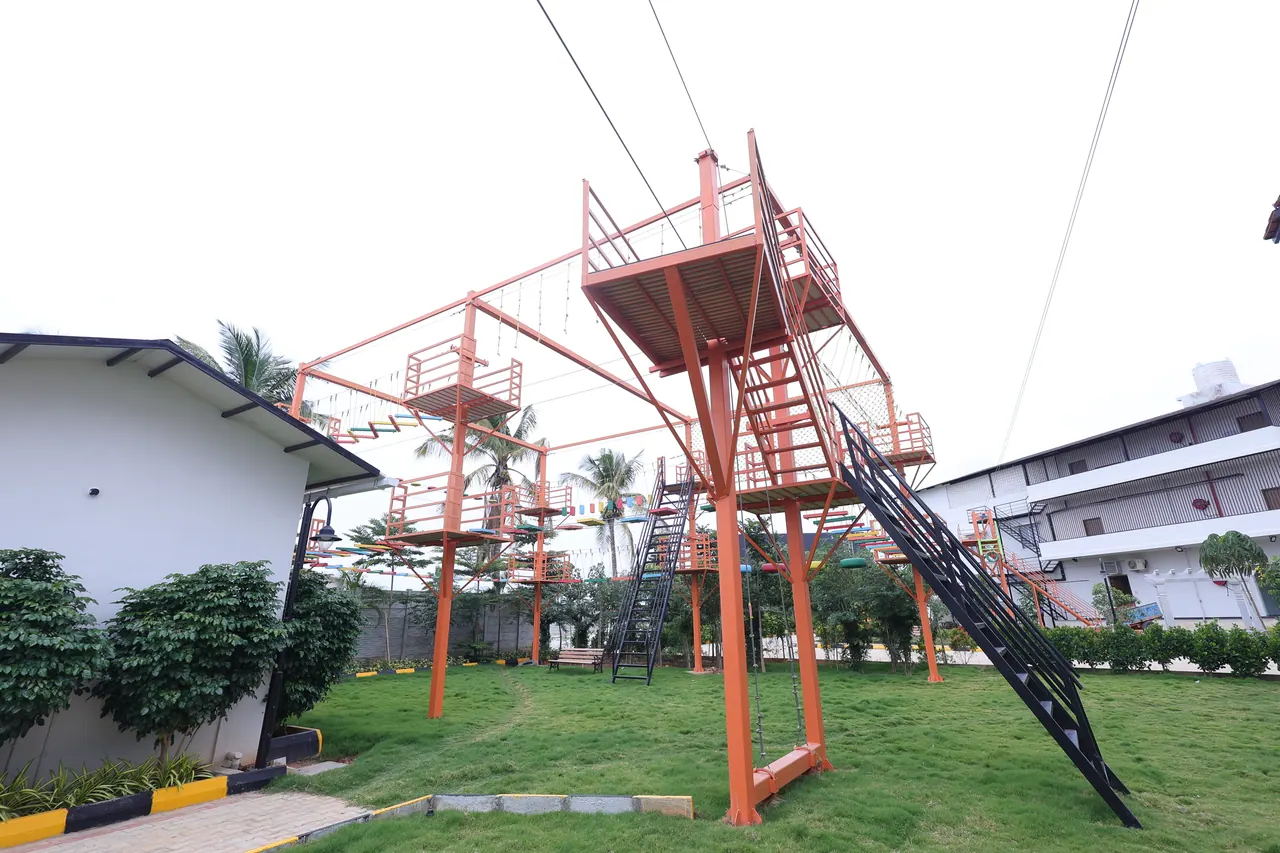 The steel adventure tower and zipline on the lawn at Sree Raaga Resorts
