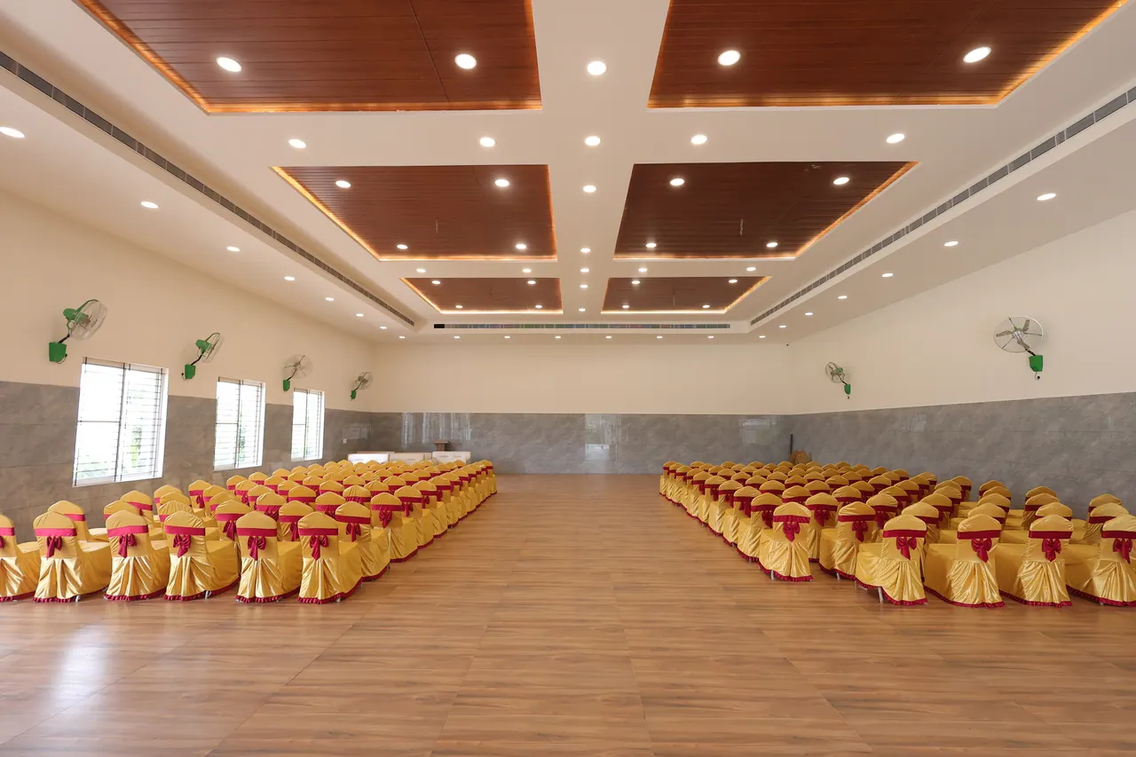 The grand banquet hall set with covered chairs for a wedding reception