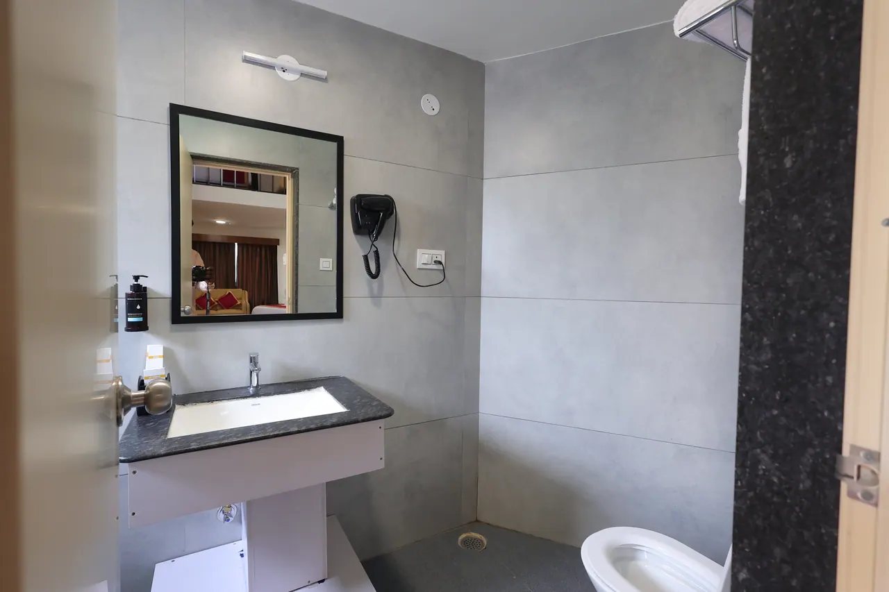 Guest bathroom with a granite-topped vanity, framed mirror and wall-mounted hairdryer