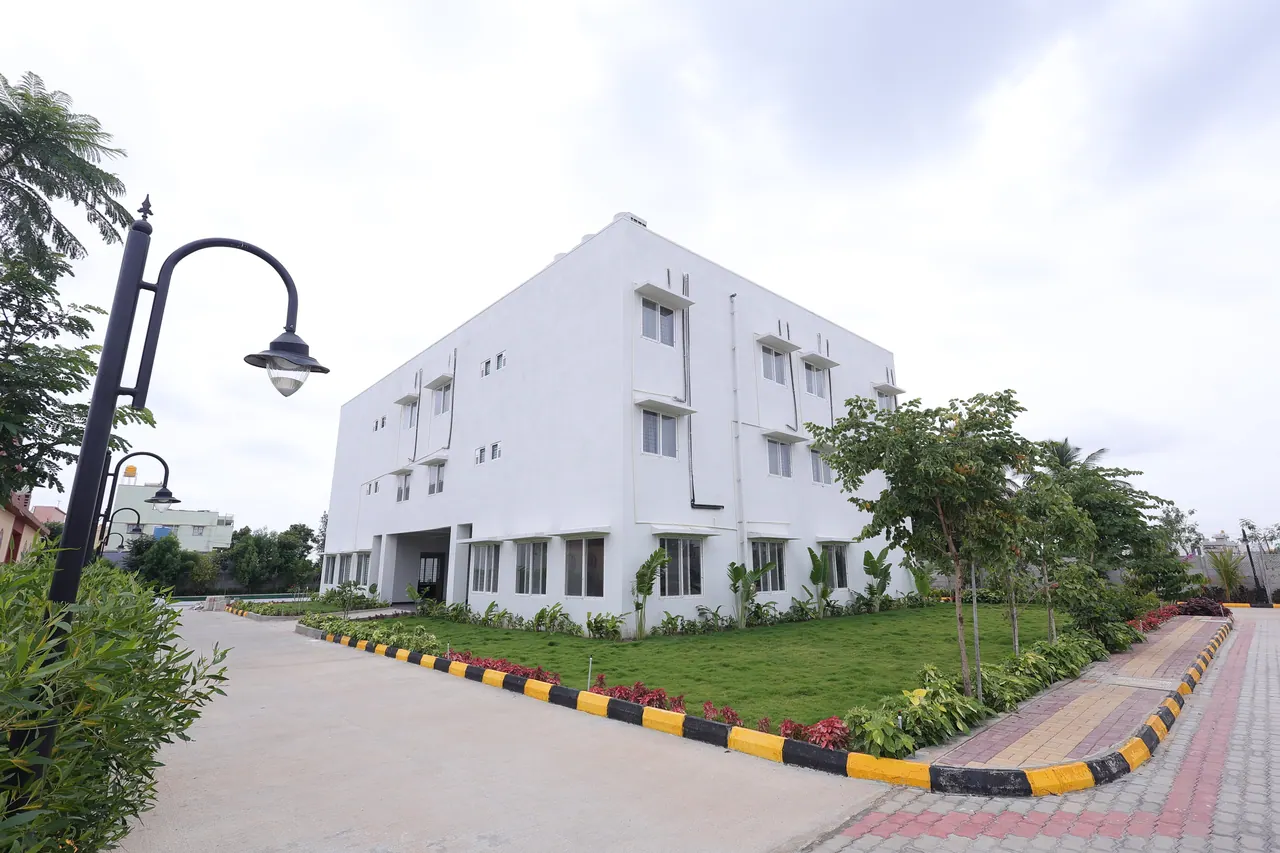 The executive block at Sree Raaga Resorts, a three-storey white building beside a mown lawn