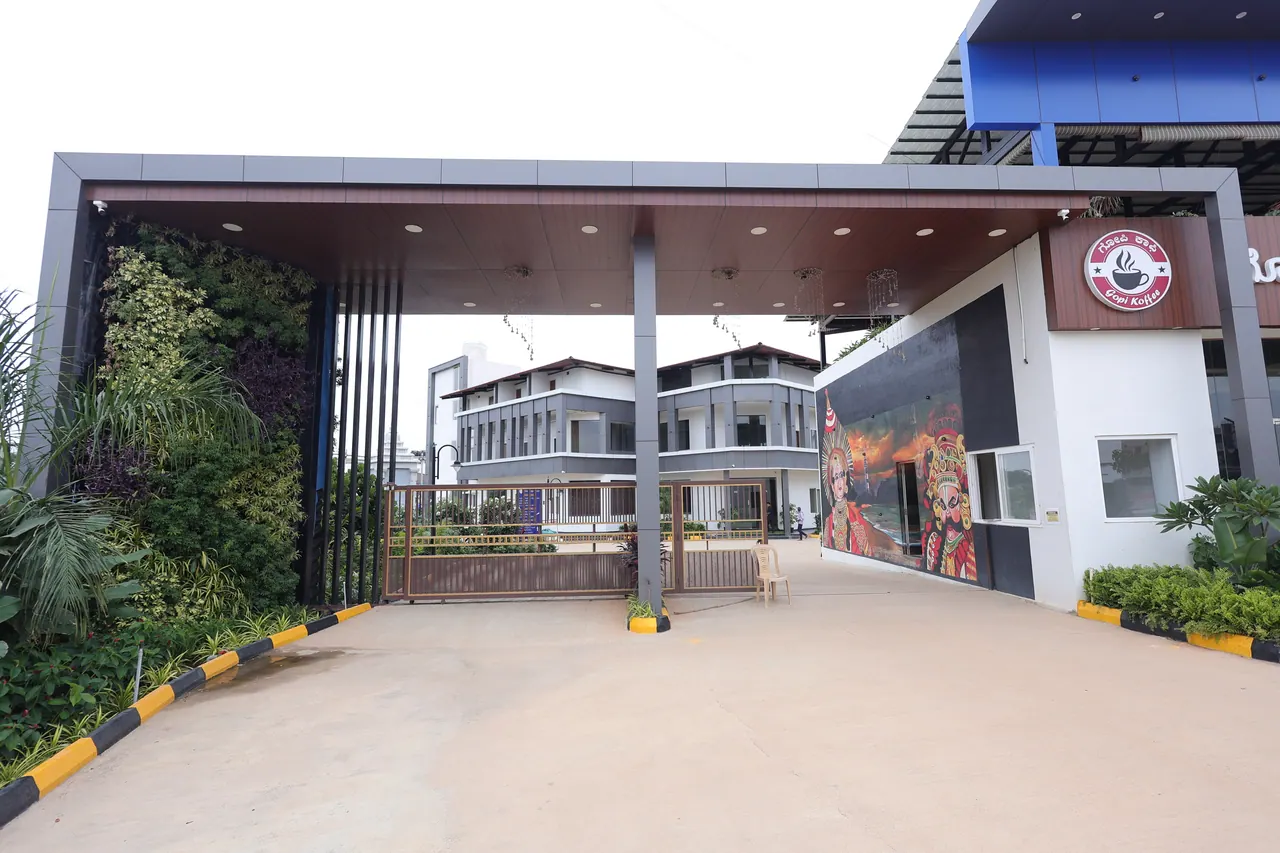 The main entrance at Sree Raaga Resorts — a steel canopy over the drive, a living green wall on one side and a painted Yakshagana mural on the other