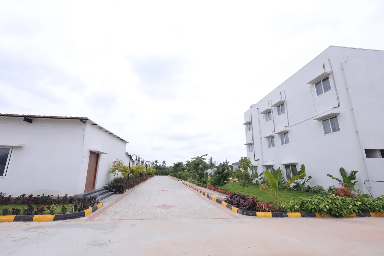 The internal road at Sree Raaga Resorts with a single-storey villa on one side and the three-storey executive rooms block on the other