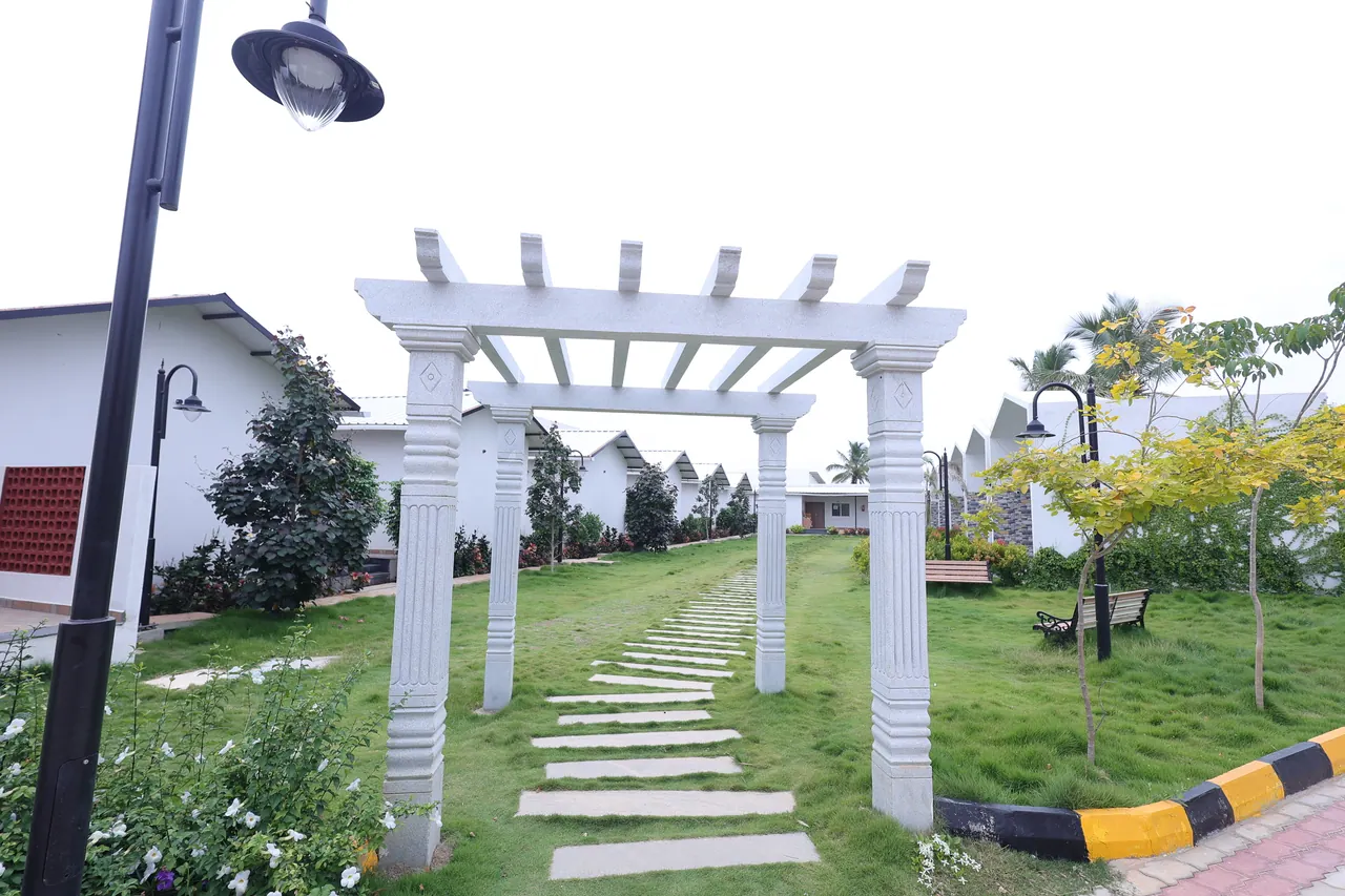 A pergola over a stepping-stone path through landscaped gardens