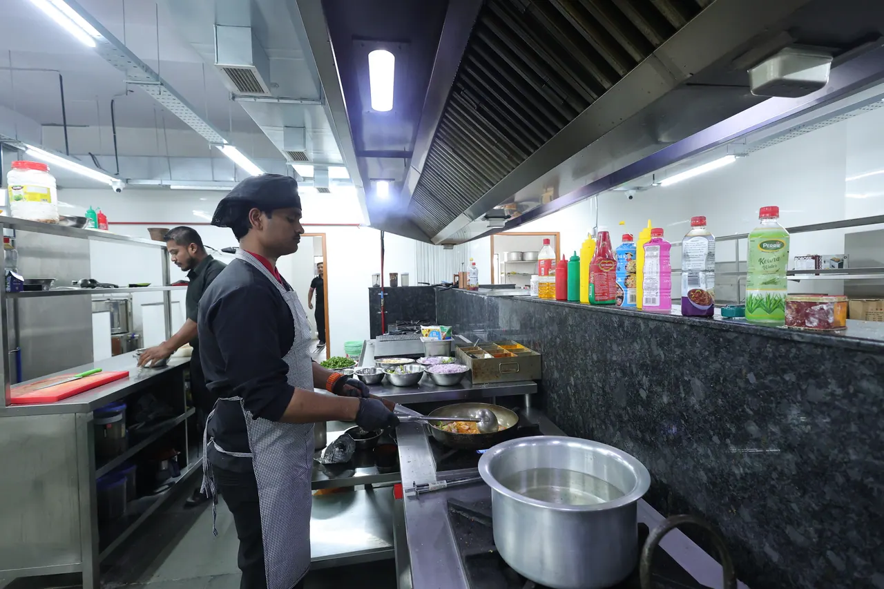 A chef working at a live cooking station in the resort kitchen