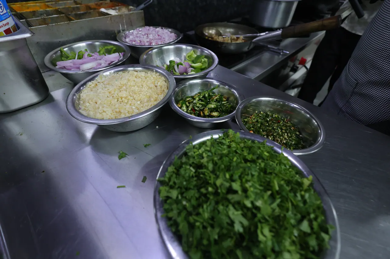 Bowls of chopped onion, chilli and coriander prepped for service
