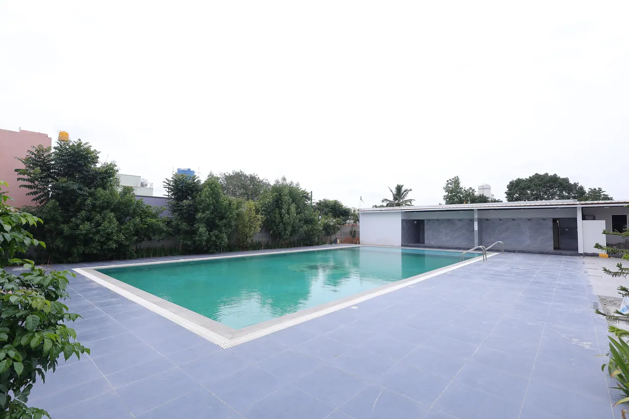 The main rectangular swimming pool at Sree Raaga Resorts with a tiled deck and changing block