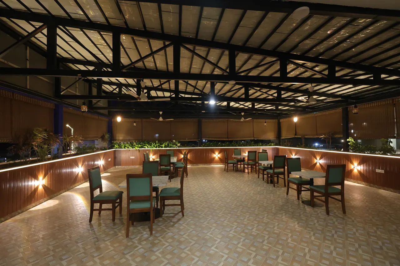 Open-air rooftop terrace dining under a lit steel canopy at Sree Raaga Resorts