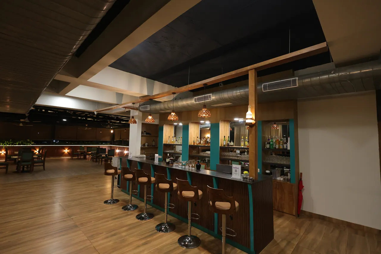 The sports bar counter with stools and backlit shelving at Sree Raaga Resorts