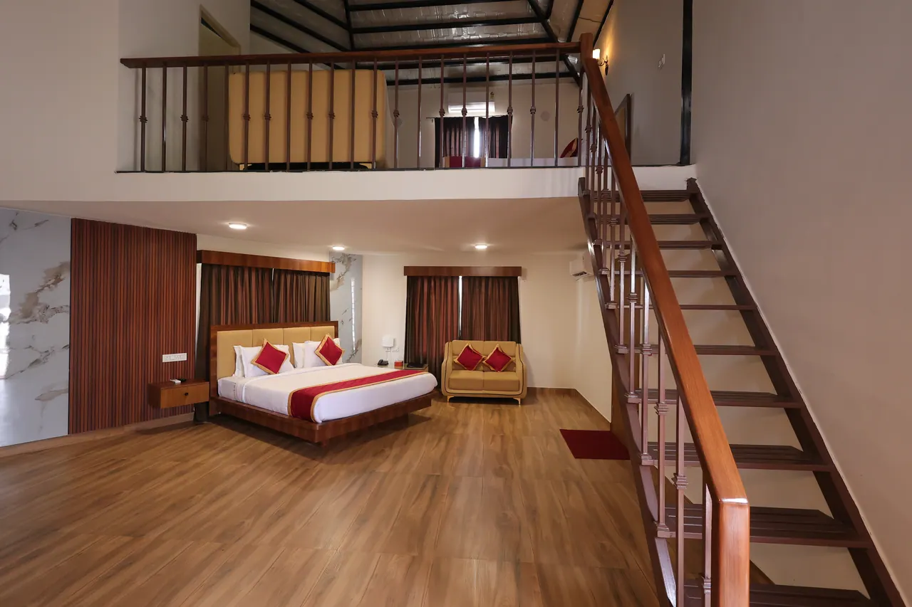 Timber staircase with turned balusters rising to a mezzanine bedroom in the duplex