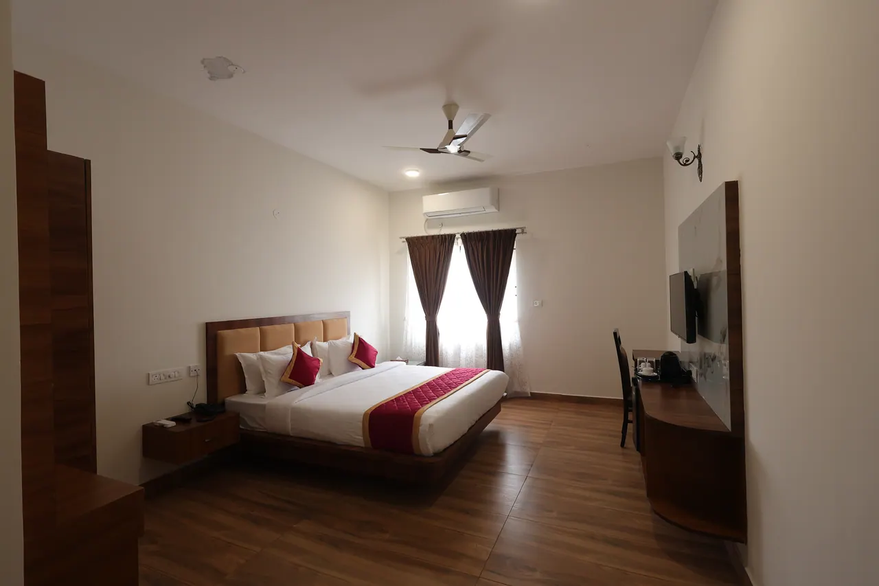 Curtained window in an executive room with daylight across the bed
