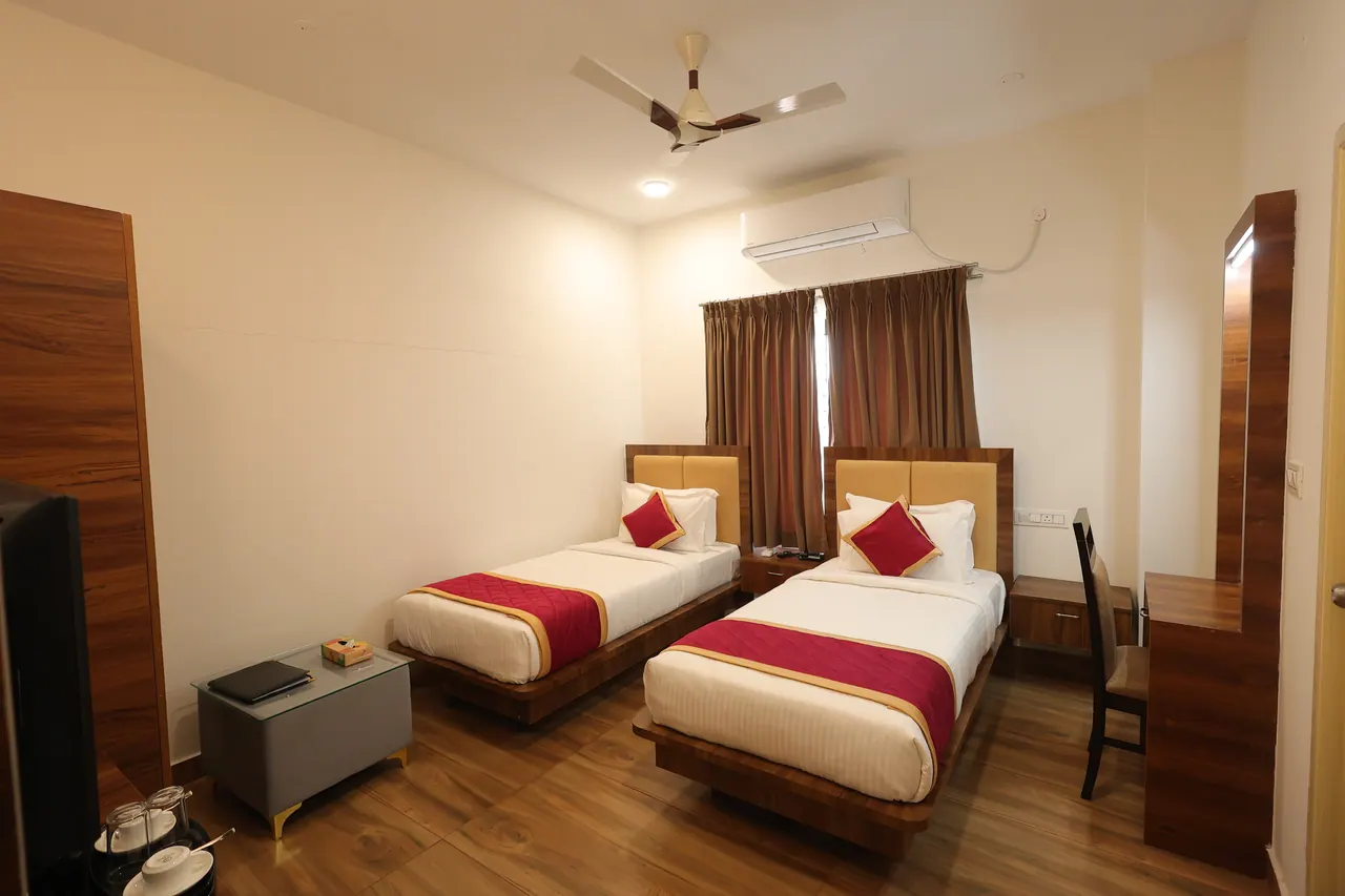 Executive room laid out with two single beds, a luggage bench and a full-length mirror