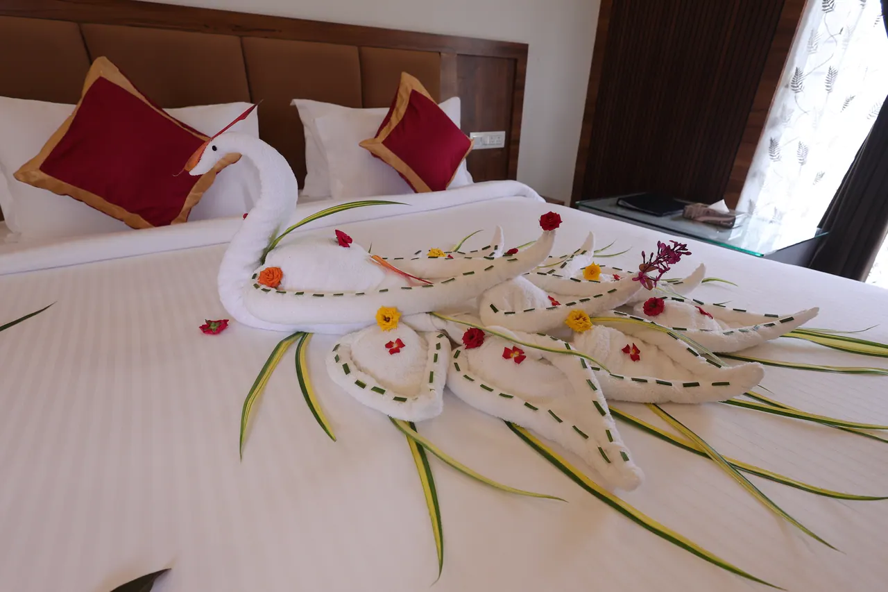 Close view of fresh flower petals arranged across a white bed in a villa
