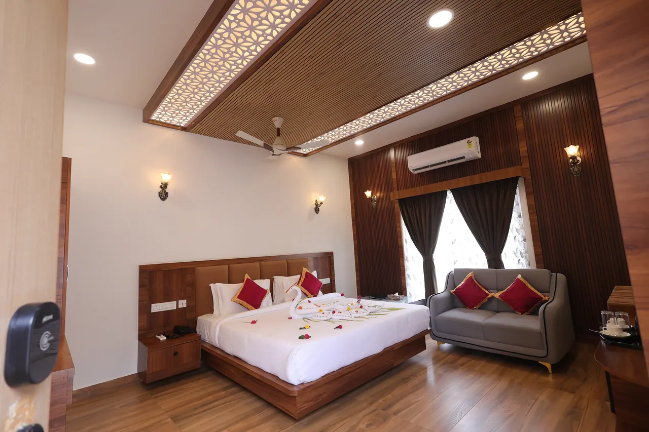 Backlit jaali lattice ceiling panel set into wooden battens above a villa bed